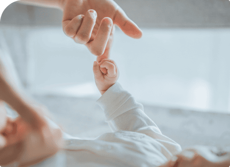 Mãe segurando a mãozinha do bebê pelo dedo na Maternidade Perinatal.