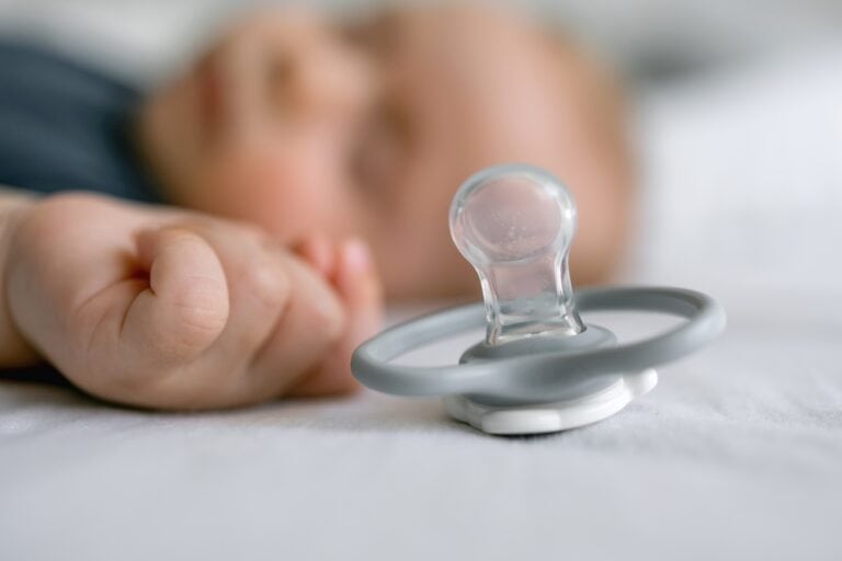 A,Pacifier,Lying,On,Bed,Near,Sleeping,Toddler.,Selective,Focus