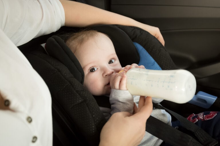 Closeup,Portrait,Of,Mother,Feeding,Baby,In,Car,From,Bottle